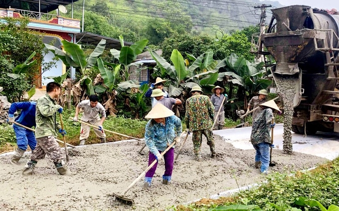 Người dân xóm Nà Chát, xã Linh Thông góp sức làm đường bê tông.