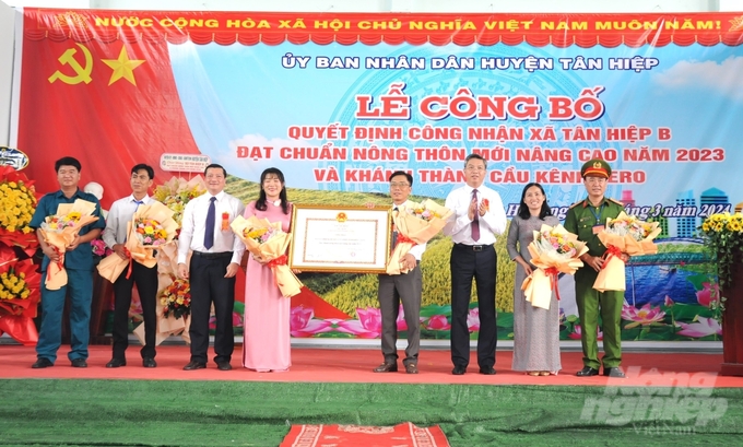 Phó Chủ tịch UBND tỉnh Kiên Giang Nguyễn Lưu Trung (thứ 3 từ phải sang) trao quyết định công nhận xã Tân Hiệp B đạt chuẩn nông thôn mới nâng cao cho đại diện chính quyền xã. Ảnh: Trung Chánh.