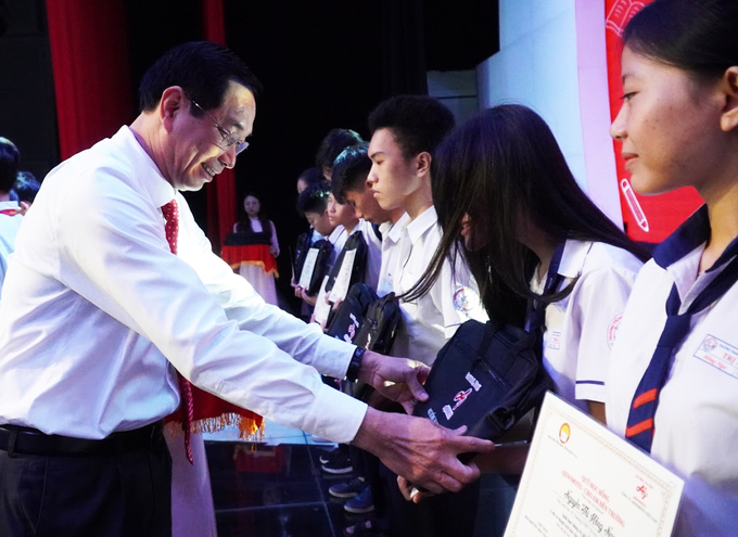 Ông Võ Văn Phi - Phó Chủ tịch UBND tỉnh Đồng Nai trao tặng cặp và bằng khen cho các em học sinh.