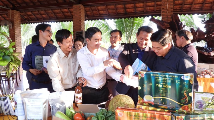 Ông Trần Quốc Duy (giữa) Giám đốc Trung tâm Xúc tiến đầu tư, Thương mại và Du lịch tỉnh Bình Phước giới thiệu nông sản nổi bật của tỉnh Bình Phước với đoàn công tác nước bạn Lào. Ảnh: Trần Trung.