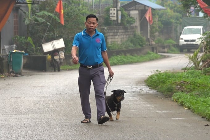 Mr. Nguyen Van Huan, a resident in Chau Son ward, Song Cong city, bringing his dog to a vaccination center. Photo: Mai Thuong.