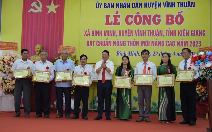 Ông Lê Trung Hồ (giữa), Bí thư Huyện ủy, Chủ tịch UBND huyện Vĩnh Thuận trao giấy khen cho các cá nhân có thành tích xuất sắc trong xây dựng nông thôn mới. Ảnh: DT.