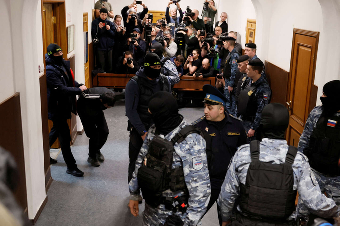 Các đối tượng khủng bố được cảnh sát áp giải đến trình diện tại tòa án quận Basmanny tại Moscow hôm 24/3. Ảnh: Reuters.