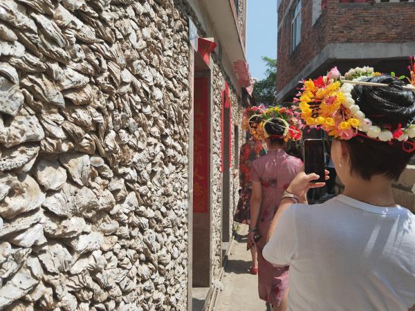 Du khách khi đến Tuyền Phố thích thú chụp ảnh với những bức tường nhà được làm từ vỏ sò.