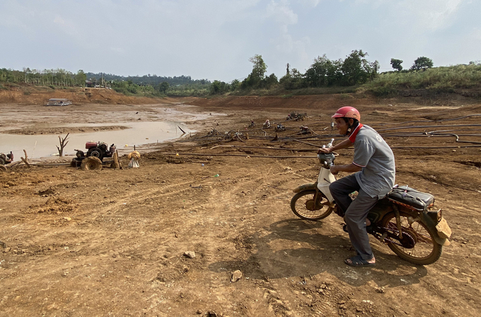 Nhiều hồ chứa nước ở khu vực Tây Nguyên cạn trơ đáy, người dân phải huy động máy bơm di động để hút nước bùn tưới cho cây. Ảnh: Quang Yên.