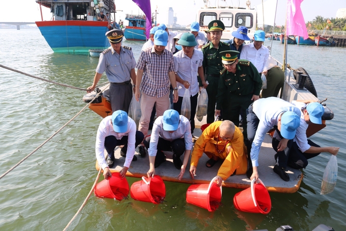 Các đại biểu tham gia thả tôm, cá giống xuống sông Nhật Lệ nhằm tái tạo nguồn lợi thủy Sản. Ảnh: V. Dung.