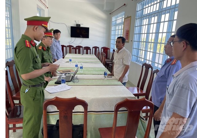 Cơ quan công an tống đạt quyết định khởi tố, bắt tạm giam đối với ông Nguyễn Minh Phúc (bìa phải). Ảnh: Công an cung cấp.