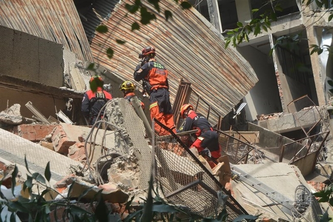 Lực lượng cứu hỏa Đài Loan nỗ lực giải cứu người mắc kẹt trong một tòa nhà bị sập. Ảnh: CNA. 
