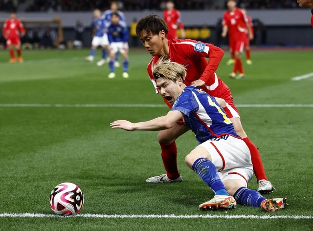 ĐT Triều Tiên (áo đỏ) đối đầu với ĐT Nhật Bản (áo xanh). Ảnh: Reuters