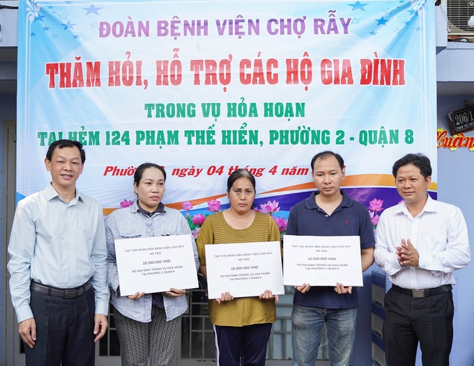 TS.BSCK2 Nguyễn Tri Thức, Giám đốc Bệnh viện Chợ Rẫy trao hỗ trợ cho các hộ dân trong vụ cháy ven kênh Tàu Hũ. Ảnh: CR.