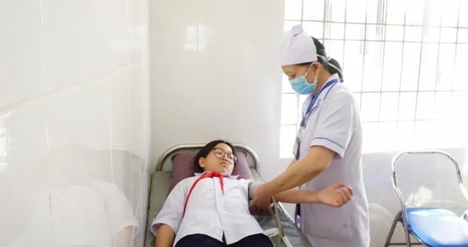 Một trong 4 học sinh ở Khánh Sơn được chăm sóc khi nhập viện nghi ngộ độc thực phẩm. Ảnh: BL.