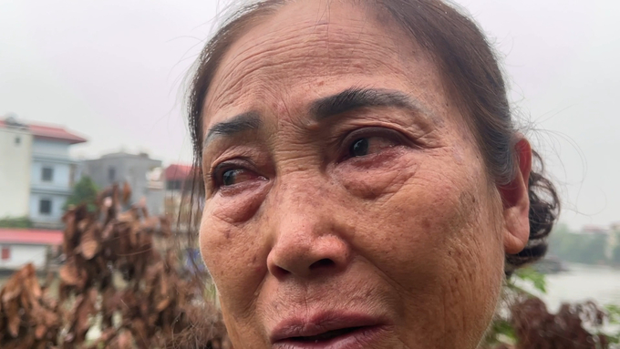 Bà Thao rơi nước mắt vì toàn bộ căn nhà đã chìm xuống lòng sông Cầu. Ảnh: Huy Bình.