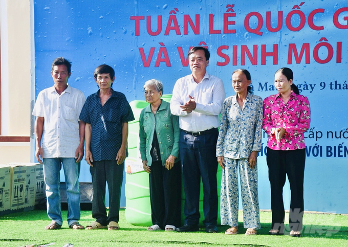 Chủ tịch UBND tỉnh Cà Mau Huỳnh Quốc Việt (thứ 3 từ phải sang) tặng bồn nước cho các hộ dân tại huyện U Minh. Ảnh: Trọng Linh.