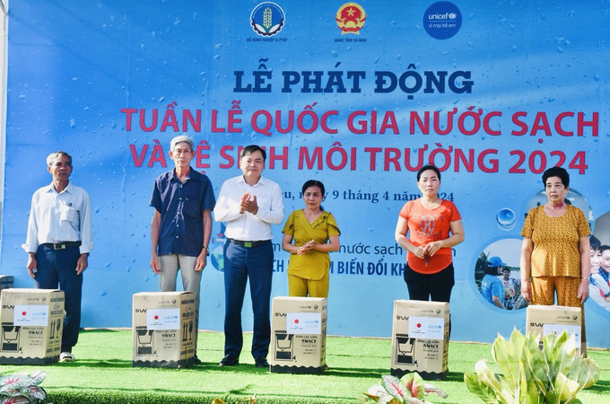 Thứ trưởng Bộ NN-PTNT Nguyễn Hoàng Hiệp (thứ 3 từ trái sang) trao máy lọc nước cho người dân. Ảnh: Trọng Linh.