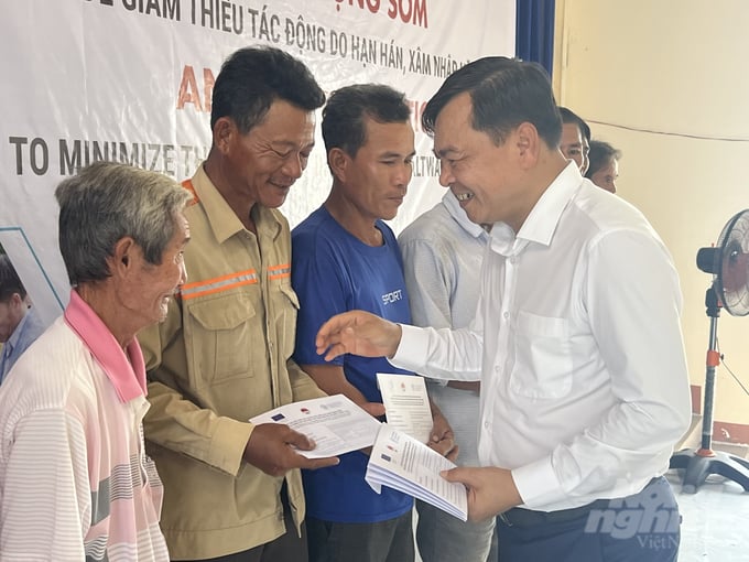 Thứ trưởng Bộ NN-PTNT Nguyễn Hoàng Hiệp trao tiền mặt cho các hộ dân tại huyện U Minh, tỉnh Cà Mau. Ảnh: Trọng Linh.