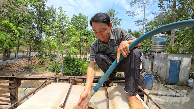 Các thành viên trong Tổ lâm nghiệp cộng đồng đang bơm nước giếng để chở đi tưới cây trong mùa khô năm nay. Ảnh: Minh Sáng.