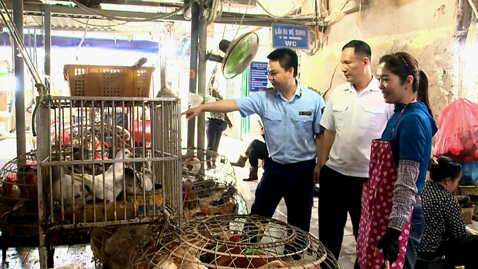 Lực lượng chức năng tăng cường tuyên truyền về cúm gia cầm cho tiểu thương tại chợ Móng Cái III (TP Móng Cái). Ảnh: Cường Vũ.