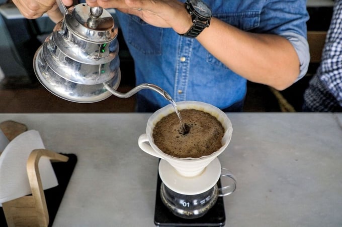 A speciality coffee shop employee serves filtered coffee. Photographer: Mohammed Huwais/AFP/Getty Images.