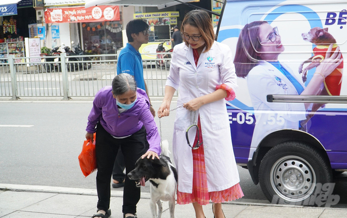 Trước đây, bà Phùng Thị Lê (áo tím) rất khó khăn mỗi khi đưa chú chó của mình đi khám bệnh. Ảnh: Lê Bình.