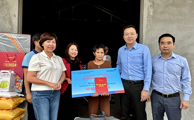 Lãnh đạo huyện Yên Bình và đại diện Ngân hàng Vietinbank trao triền hỗ trợ làm nhà ở cho hộ nghèo. Ảnh: Thanh Tiến.