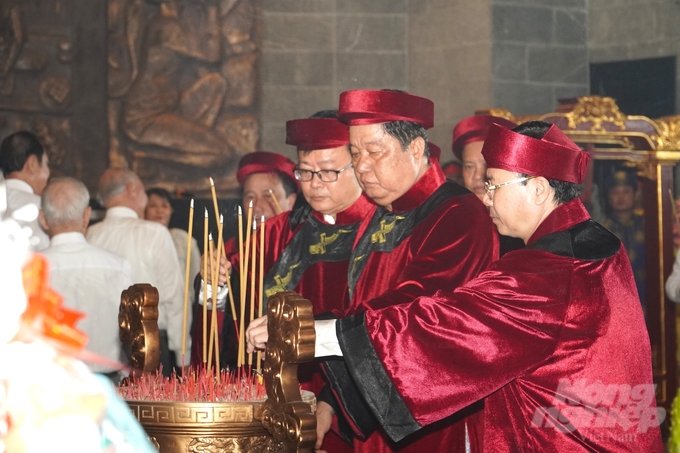 Các đại biểu dâng hương tưởng niệm, tri ân công đức Vua Hùng và các bậc tiền nhân tại lư hương trước điện thờ.