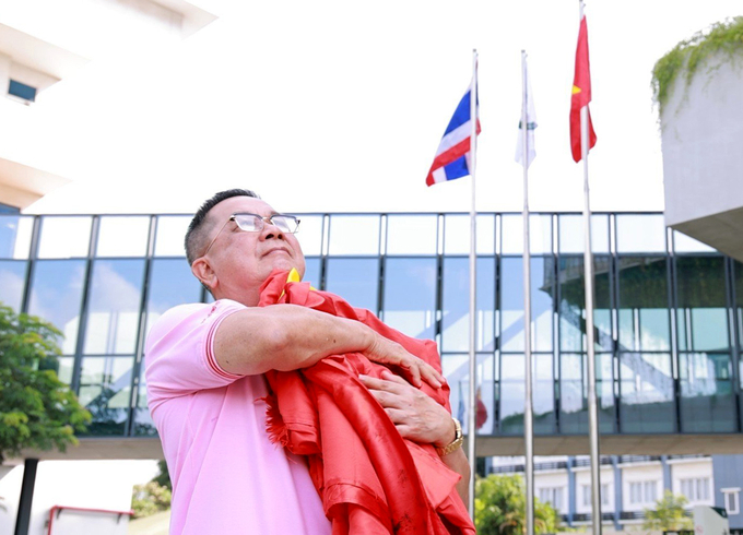 Ông Sooksunt Jiumjaiswanglerg kính cẩn nâng niu lá Quốc kỳ Việt Nam.
