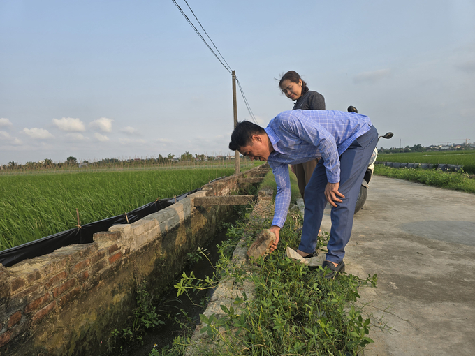 Ông Nguyễn Tiến Dũng, Trưởng thôn Hỗ Đông chia sẻ với PV về những khó khăn trong việc sửa chữa hệ thống kênh mương phục vụ sản xuất. Ảnh: Đinh Mười.