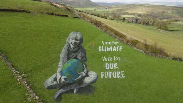 Nghệ sĩ Jamie Wardley đã tạo ra bức tranh nhân Ngày Trái đất với thông điệp 'Bỏ phiếu cho khí hậu, bỏ phiếu cho tương lai của chúng ta'. Ảnh: AFP.