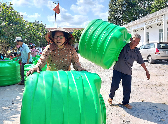 Bà con xã Tân Lợi Thạnh, huyện Giồng Trôm nhận bồn nước từ nhà tài trợ. Ảnh: Kiều Trang.