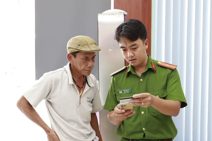 Cán bộ Công an hướng dẫn người dân Thừa Thiên - Huế  thực hiện thủ tục cấp phiếu lý lịch tư pháp trên ứng dụng VNeID ngày 22/4. Ảnh: NMP.