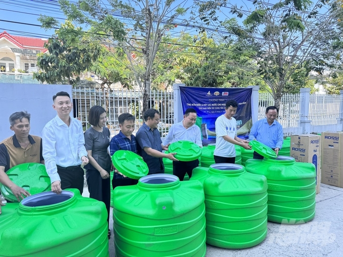 Lãnh đạo Tập đoàn Tân Á Đại Thành, Báo Nông nghiệp Việt Nam và Sở NN-PTNT Kiên Giang trao tặng bồn nước cho các hộ dân vùng bị ảnh hưởng hạn, mặn. Ảnh: Trung Chánh. 