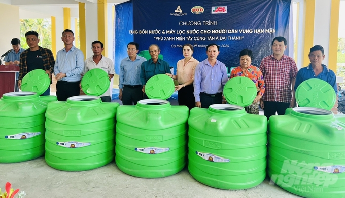 Đại diện Báo Nông nghiệp Việt Nam, Tập đoàn Tân Á Đại Thành trao tặng 20 bồn nước cho người dân huyện Trần Văn Thời. Ảnh: Trọng Linh.