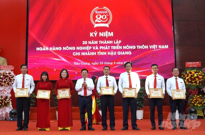 Ông Lê Viết Quyền, Giám đốc Agribank Hậu Giang trao giấy khen cho 7 tập thể có thành tích xuất sắc, đóng góp vào sự phát triển của Agribank trong suốt 20 năm qua. Ảnh: Minh Khương.