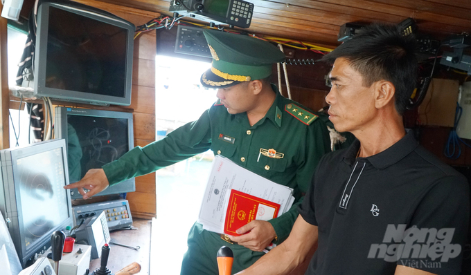 Cán bộ Bộ đội biên phòng Bến Đầm (huyện Côn Đảo) đang thực hiện kiểm tra việc lắp thiết bị và nhật ký khai thác điện tử của tàu cá trước khi xuất cảng. Ảnh: Lê Bình.