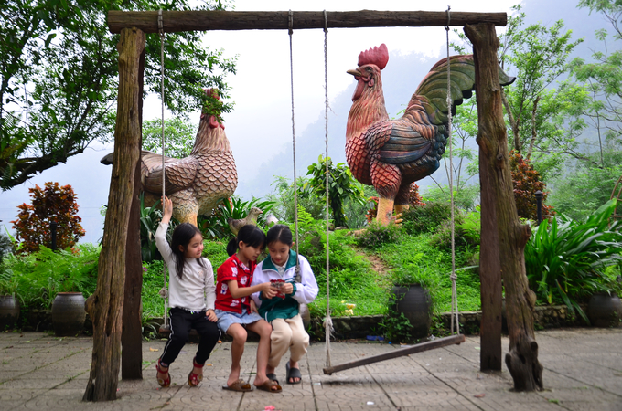 Trẻ con cùng bản vui chơi dưới tượng gà chín cựa. Ảnh: Dương Đình Tường.