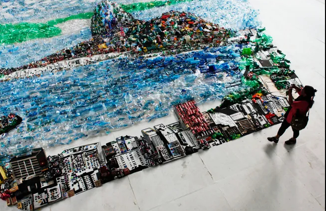 A woman takes a picture of an image of Guanabara Bay made of recycled trash, part of an installation by Brazilian plastic artist Vik Muniz, during the Rio+20 United Nations Conference on Sustainable Development summit in Rio de Janeiro June 22, 2012.