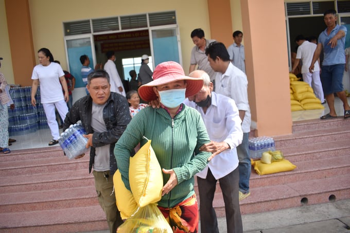 Một hộ dân ở xã Tân Điền có hoàn cảnh khó khăn, bị bướu hai mắt được người dân dẫn đến nhận quà của nhà tài trợ. Ảnh: Minh Đảm.