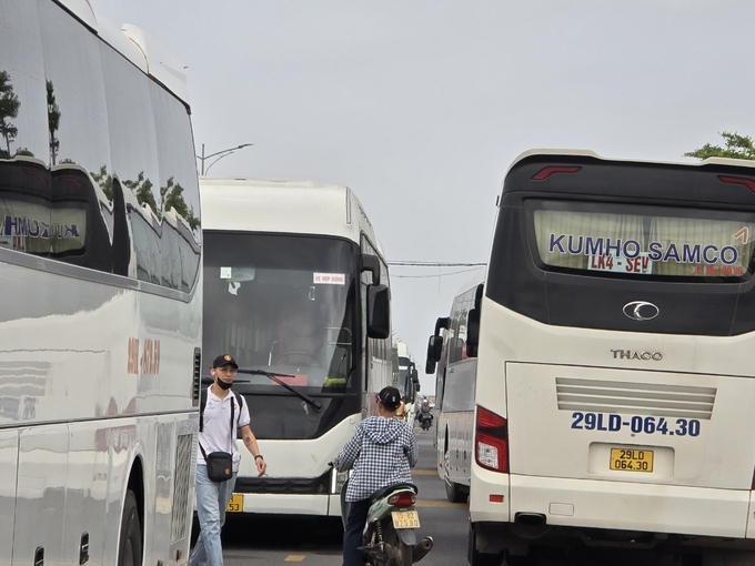 Những chiếc xe chở khách du lịch theo tour xếp hàng dài. Ảnh: Đinh Mười.