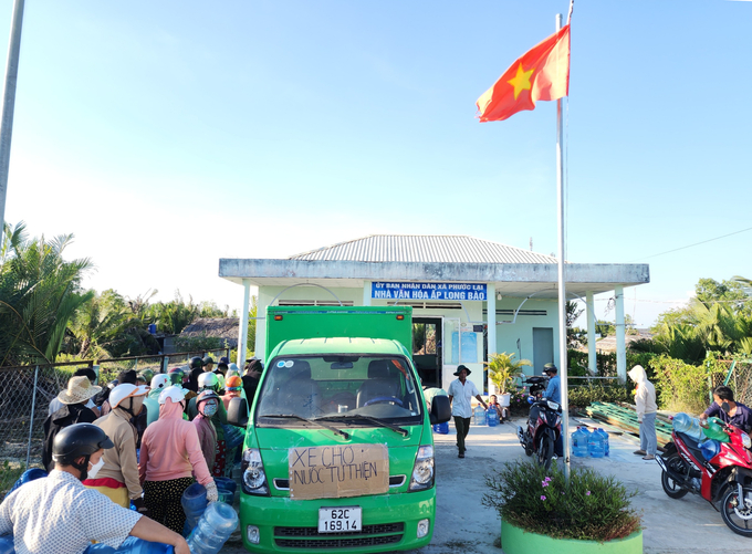 Người dân ấp Long Bào, xã Phước Lại, huyện Cần Giuộc, tỉnh Long An đến nhận nước ngọt do Nhóm Thiện nguyện G9 - Vì nụ cười trẻ thơ vận động tài trợ. Ảnh: Minh Đảm.