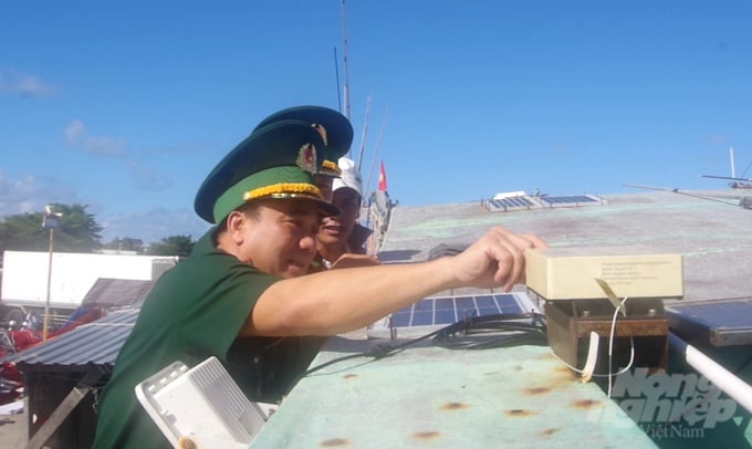 Senior Colonel Phan Anh Hiep inspecting the installation of vessel monitoring system on fishing vessels. Photo: Van Danh.