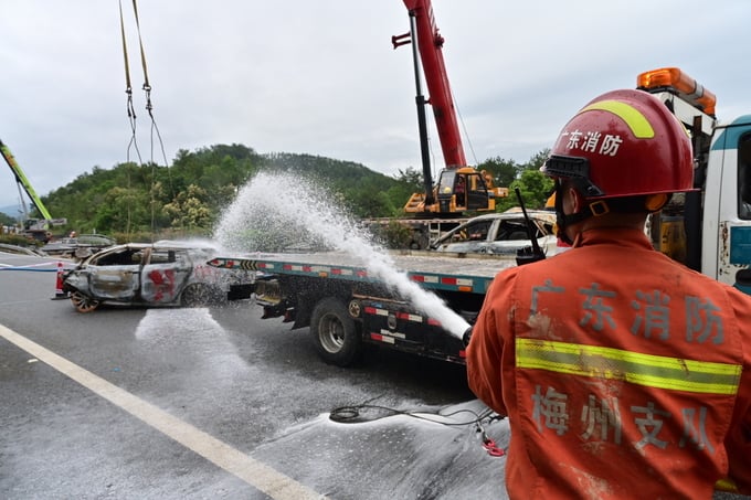 Lính cứu hỏa dập lửa tại hiện trường một đoạn đường bị sập trên đường cao tốc Mai Châu - Đại Bộ ở Mai Châu, tỉnh Quảng Đông, Trung Quốc, ngày 1/5. Ảnh: Xinhua.