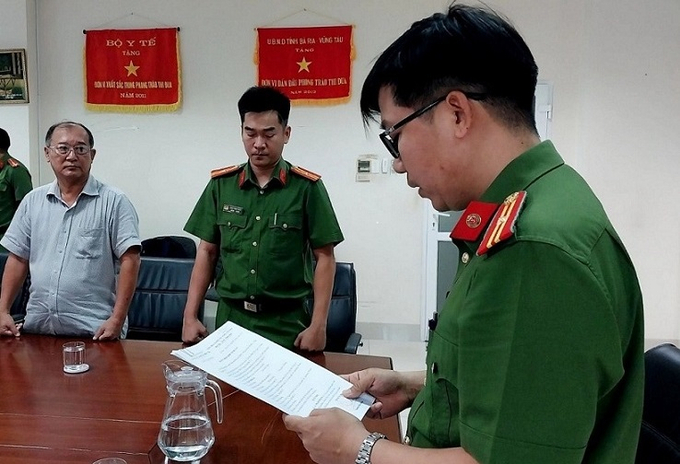 Công an tỉnh tống đạt các quyết định đến ông Phạm Minh An (bìa trái). Ảnh: Cơ quan Công an cung cấp.
