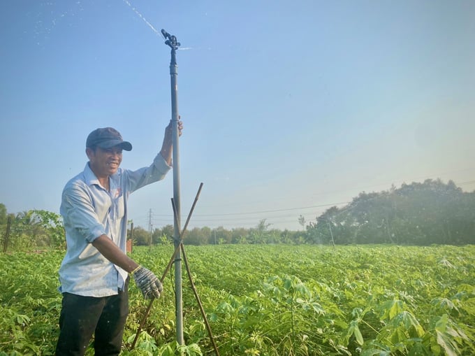 Mr Nguyen Van Cho with his family's automated irrigation technology in the cassava field. Photo: Tran Trung.