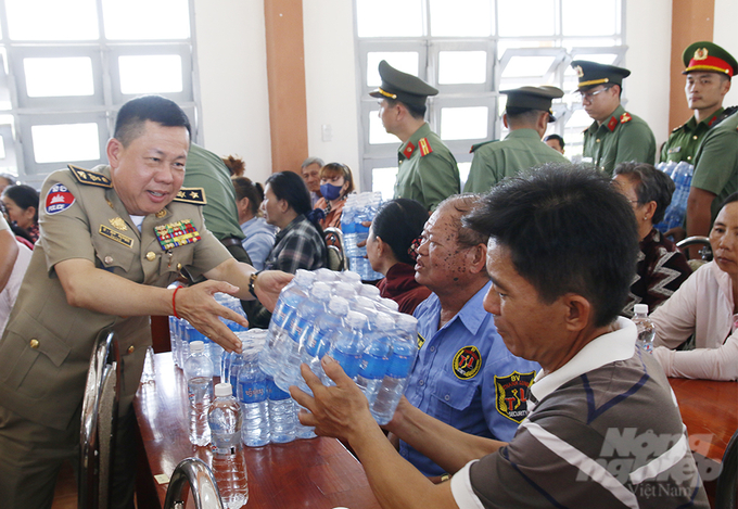 Thiếu tướng Top Sovan, Phó Giám đốc Công an tỉnh Kandal trao nước suối cho người dân. Ảnh: TT.