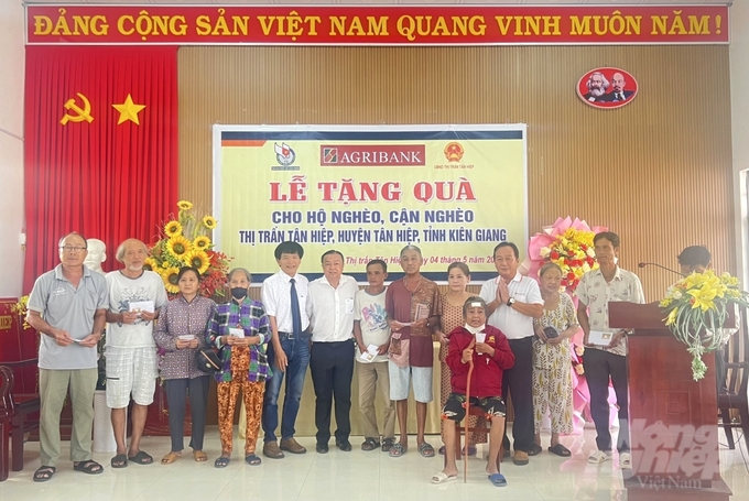 Văn phòng đại diện Agribank khu vực Tây Nam bộ, Hội Nhà báo TP Hồ Chí Minh và Ủy ban Mặt trận Tổ quốc Việt Nam thị trấn Tân Hiệp trao quà cho bà con. Ảnh: Minh Khương.