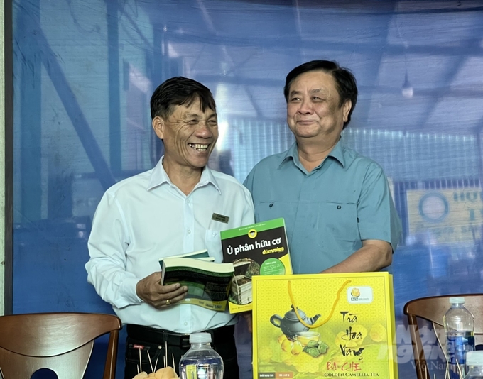 Bộ trưởng Lê Minh Hoan tặng sách HTX tại điểm khảo sát. Ảnh: HT.