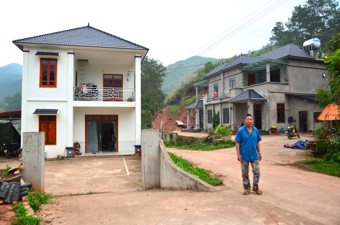 Bên phải của ông Hoàng Văn Sáu là biệt thự to nhất bản của anh Tô Xuân Trường. Ảnh: Dương Đình Tường.