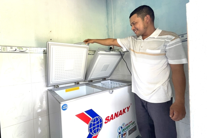 Ông Lê Văn Mai, người dân làng Canh Giao vừa mua tủ làm lạnh mới để sử dụng trong gia đình. Ảnh: V.Đ.T.