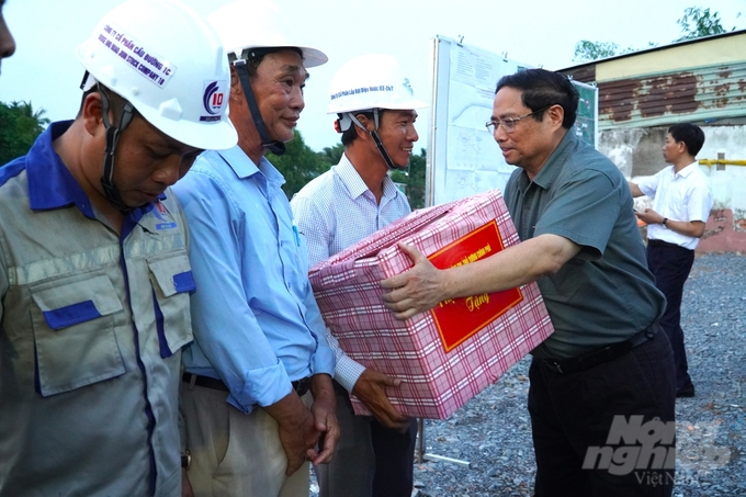 Thủ tướng Phạm Minh Chính tặng quà cho công nhân đang thi công tại công trình Dự án Kè chống sạt lở khẩn cấp sông Trà Nóc. Ảnh: Kim Anh.