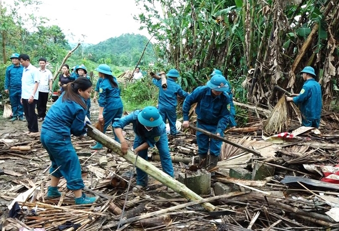 Lực lượng dân quân tự vệ giúp đỡ các nhà dân bị ảnh hưởng, dọn dẹp đường giao thông bị sạt lở… Ảnh: Phạm Hiếu.